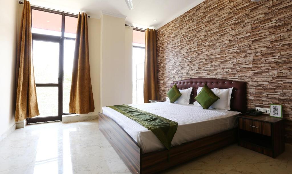 a bedroom with a brick wall and a bed at Treebo Trend Blessing Bells in Dehradun