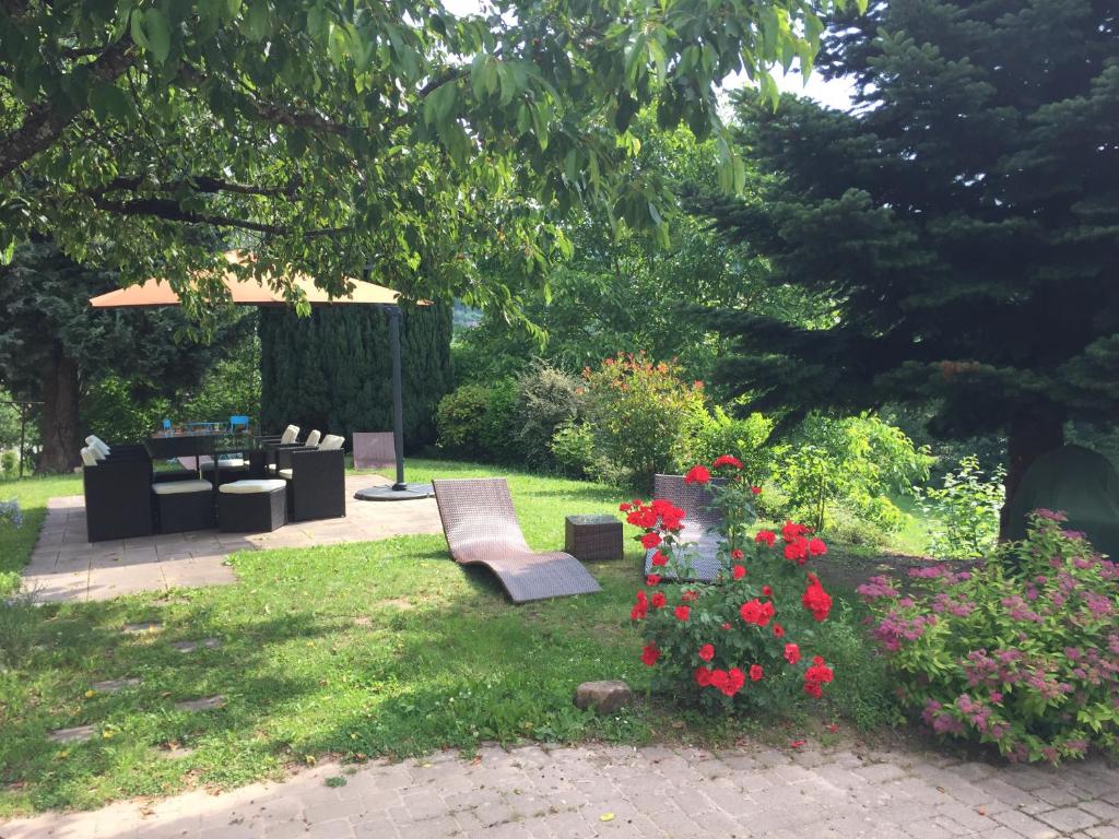 ogród ze stołem, krzesłami i kwiatami w obiekcie Le Vieux Ruisseau w mieście Lapoutroie