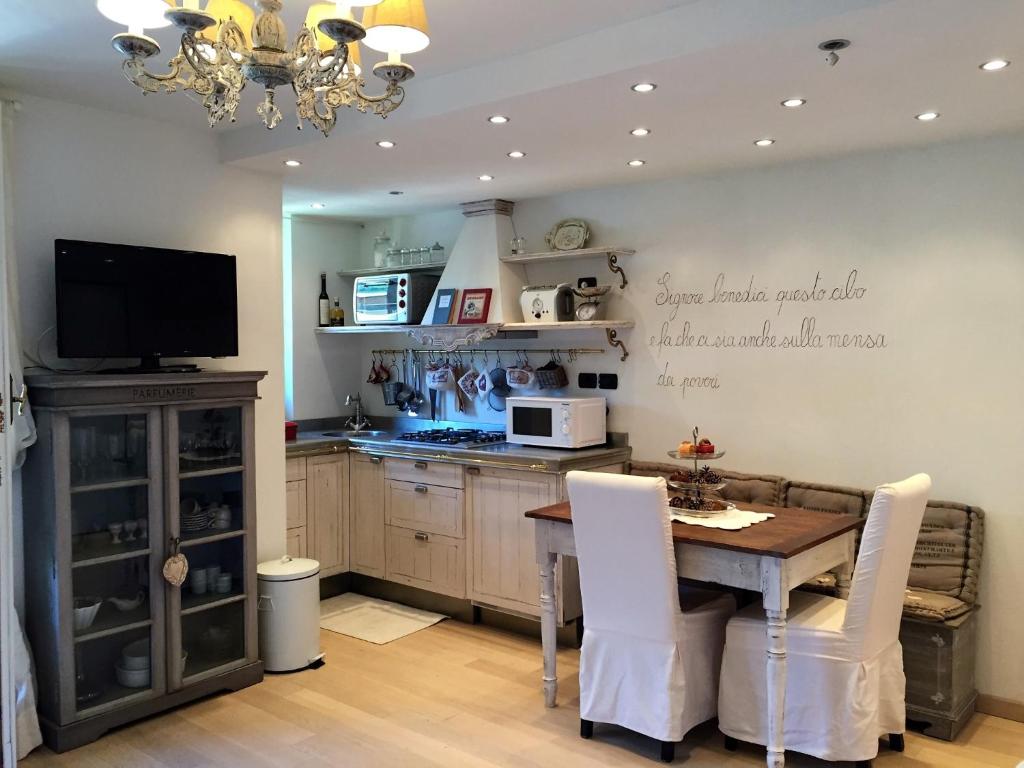 a kitchen with a table with chairs and a microwave at Margot House by Holiday World in Limone Piemonte