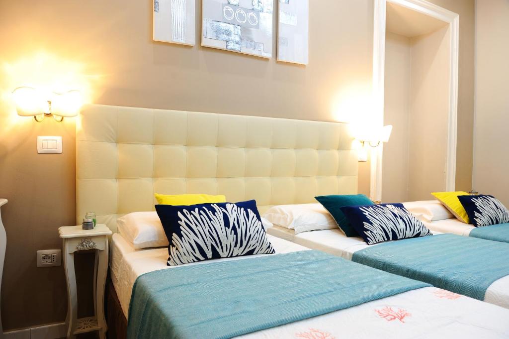 two beds in a hotel room with two beds at Onda Marina Rooms in Cagliari