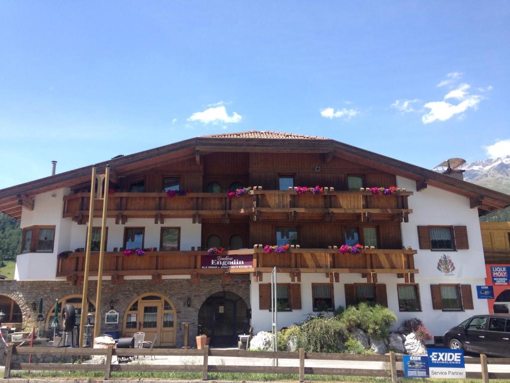 a building with a balcony with flowers on it at Landhaus Engadin in Nauders