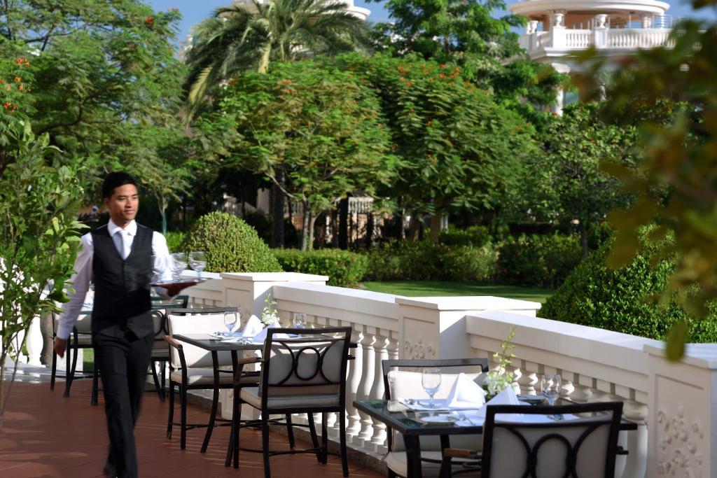a man in a tuxedo standing in front of a table at Kempinski Hotel Palm Jumeirah in Dubai