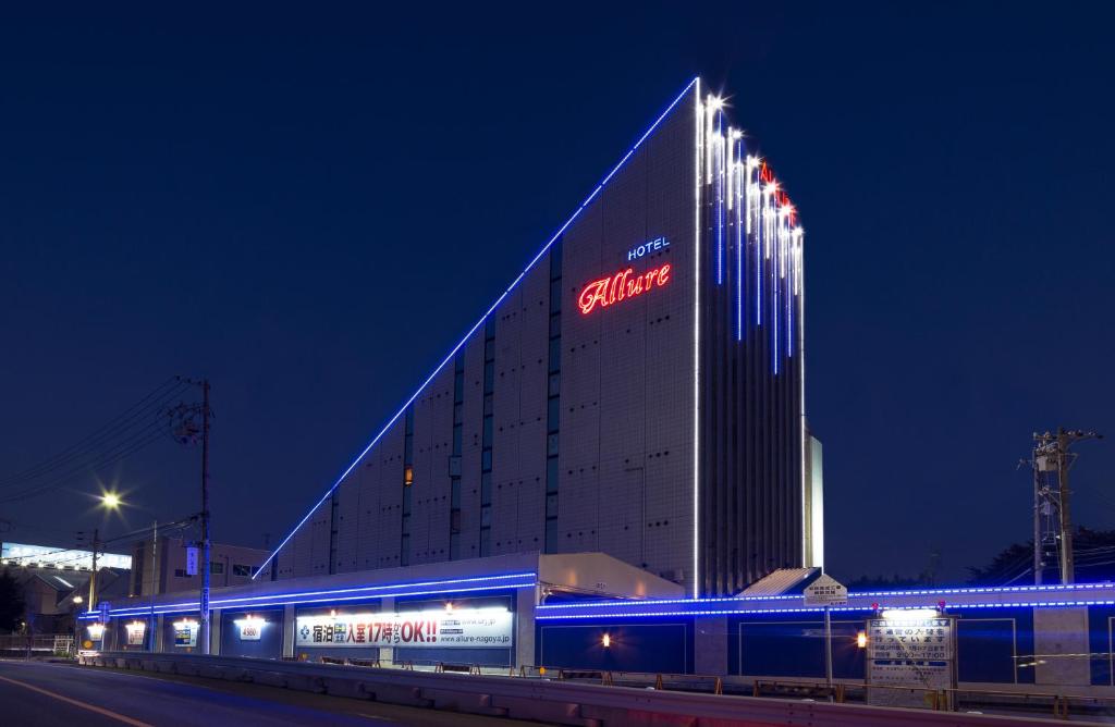 a building with a sign on the side of it at night at Hotel Allure (Adult Only) in Nagoya