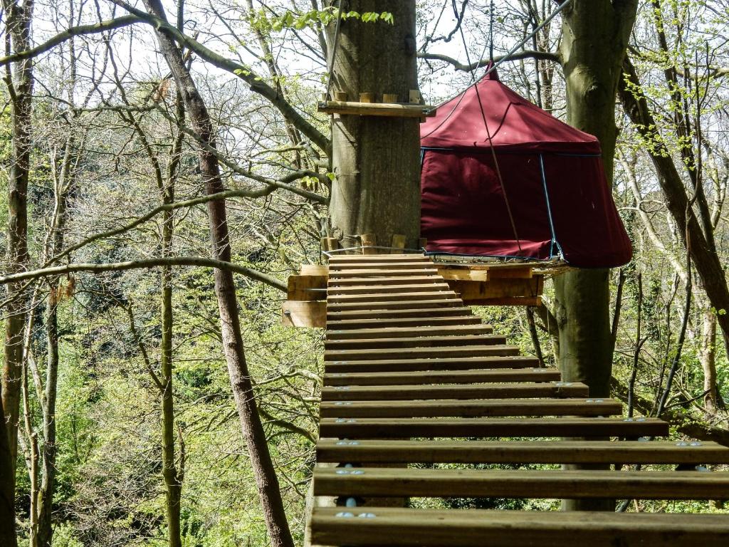 una casa en el árbol con un dosel rojo en el bosque en Woody Park, en Fécamp