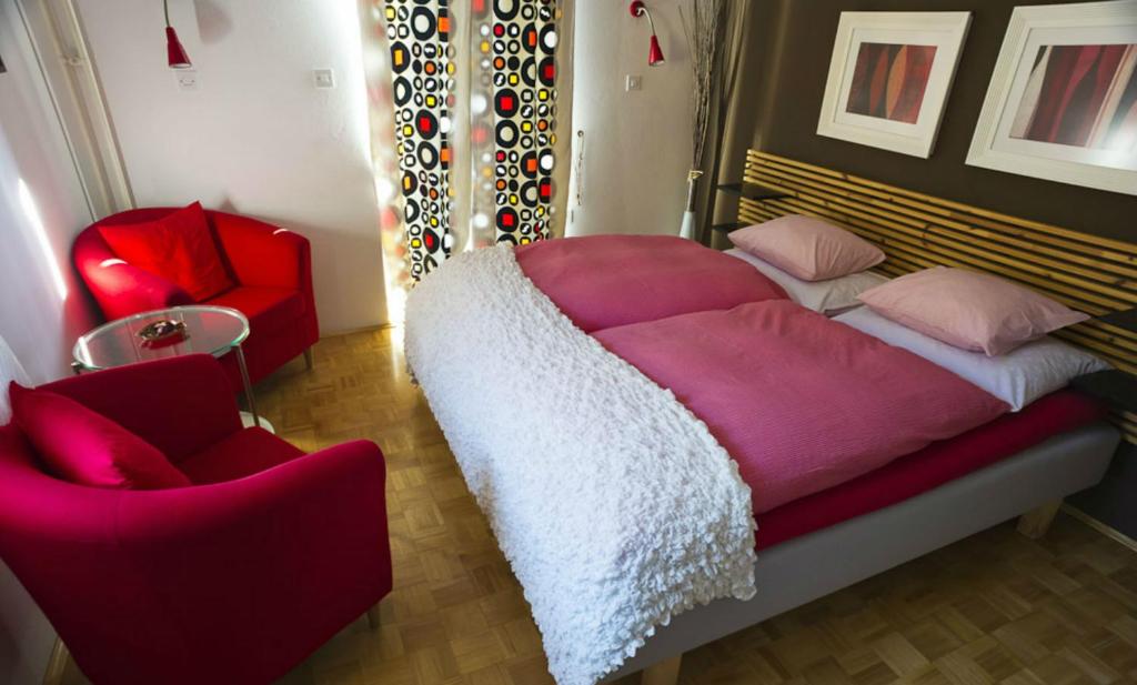 a bedroom with a large bed and a chair at House Raduha - depandansa in Luče