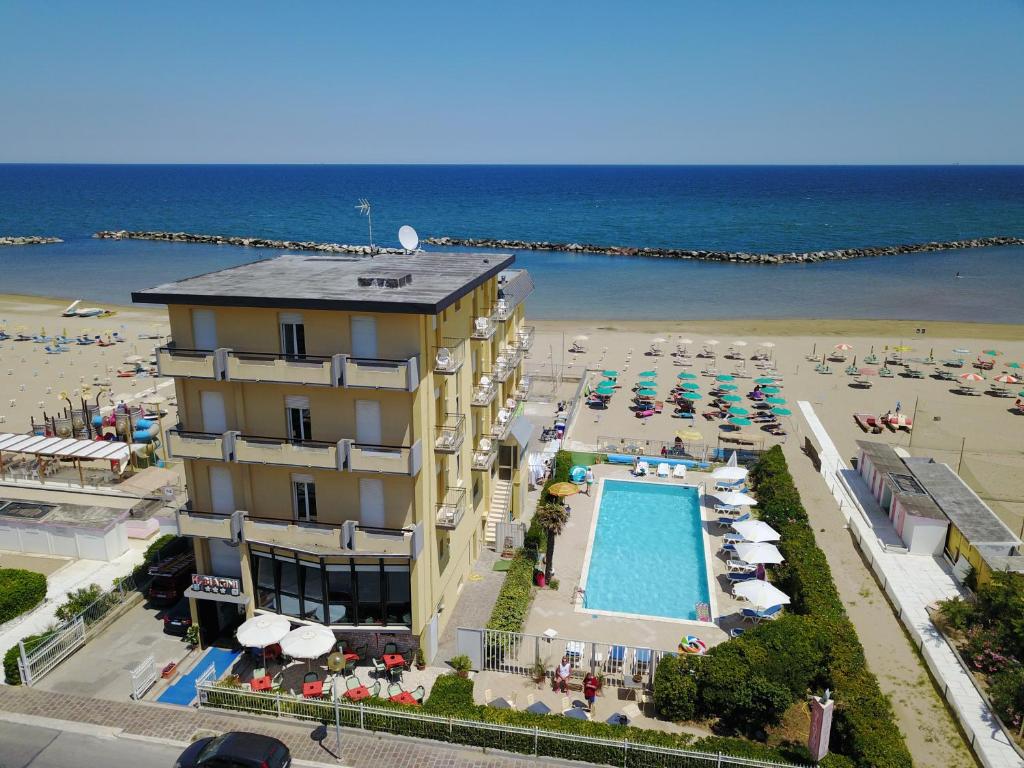 um hotel com uma piscina ao lado de uma praia em Hotel Biagini em Rimini