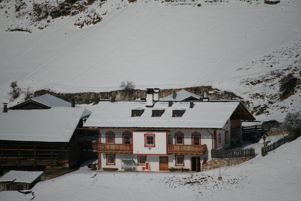 uma casa com neve em cima em Agriturismo Maso Larciunei em Selva di Val Gardena