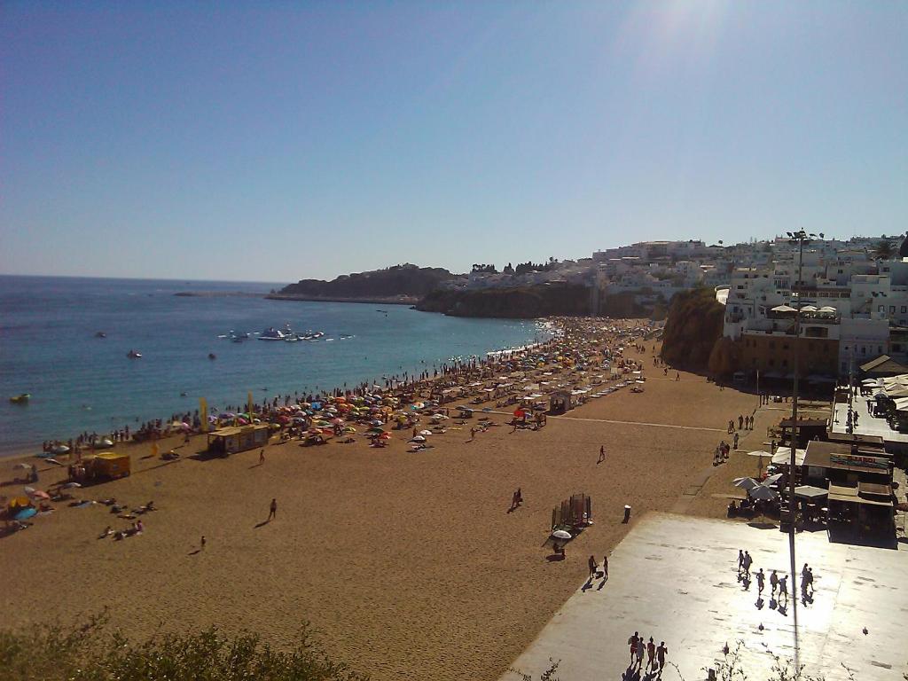 a beach with a lot of people and the ocean at Edifice Ibérico in Albufeira