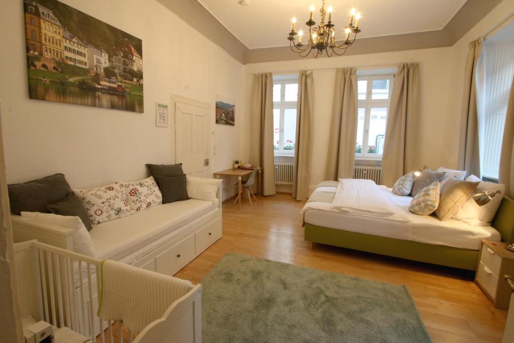 Hotel Sudpfanne في هايدلبرغ: غرفة معيشة مع أريكة وطاولة ونوافذ