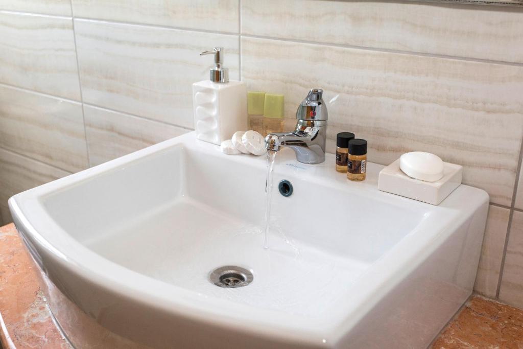 a white sink with a faucet in a bathroom at The Old Town hall in Parga