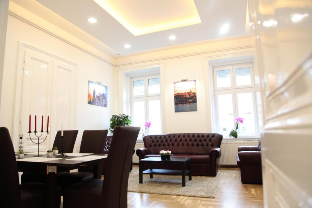 a living room with a couch and tables and windows at Brand New Apartment Budapest in Budapest