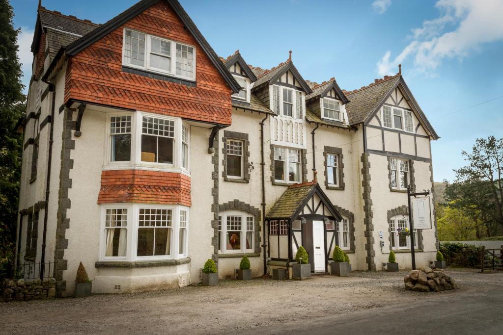 uma casa grande com janelas brancas numa rua em Stanley House em Eskdale