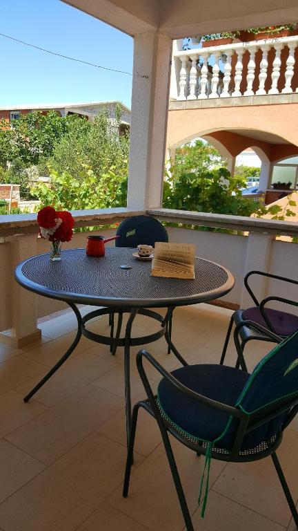 a table and chairs on a balcony with a table and flowers at Apartments Lampion in Vir