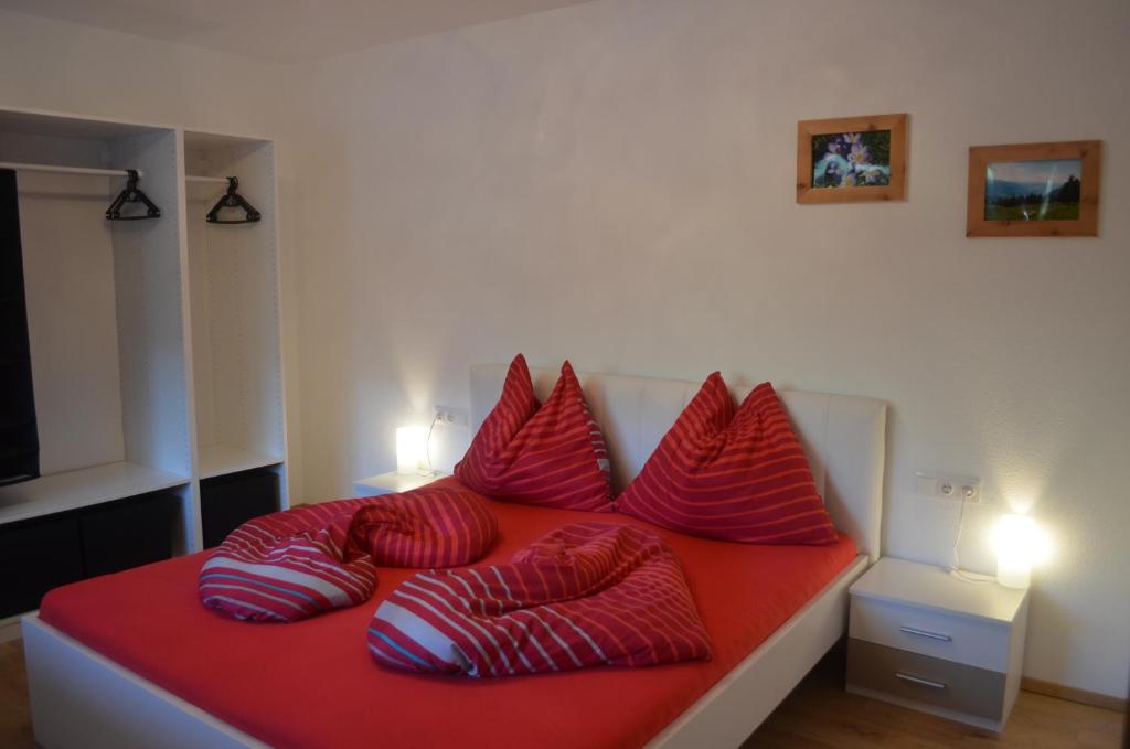 Apartment Klein & Fein في سخليترس: سرير عليه وسائد حمراء وبيضاء