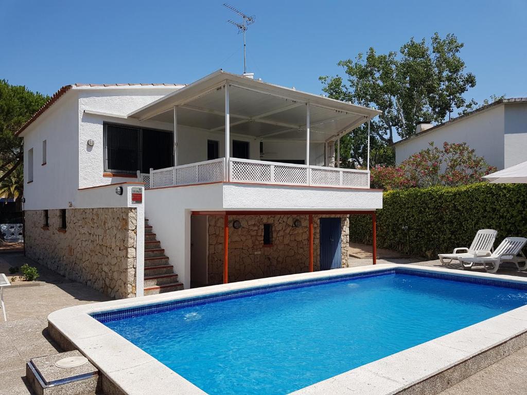 una casa con piscina frente a una casa en Casa Lorca en Roses