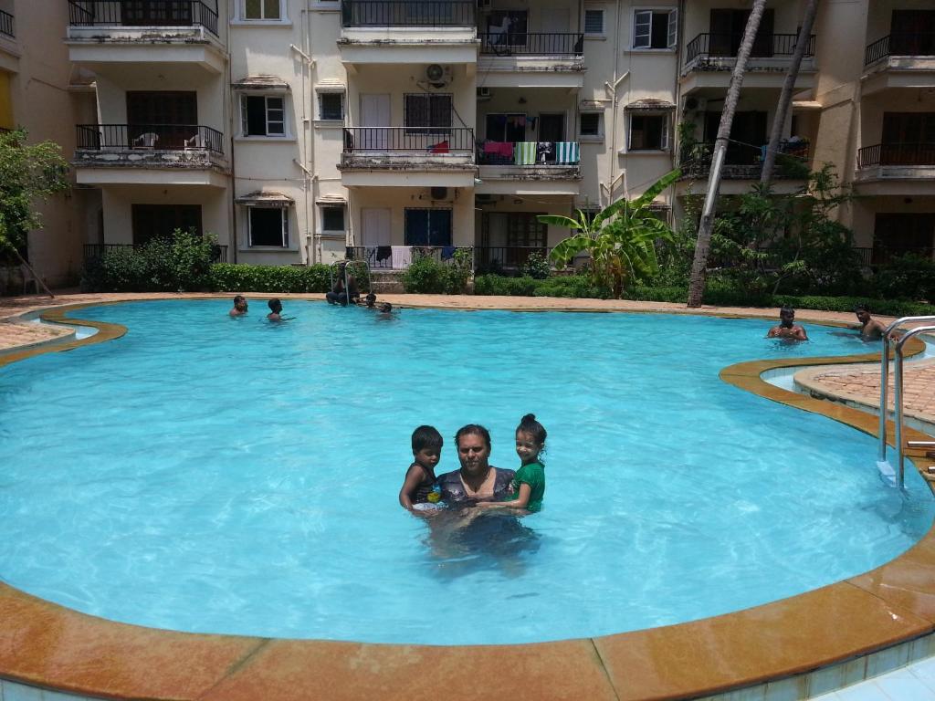 a group of three children in a swimming pool at Mariano Gracinda resort in Calangute