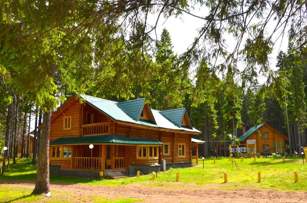 a log cabin in the woods with a tree at Holiday Park Russkaya Usadba in Zabor'ye