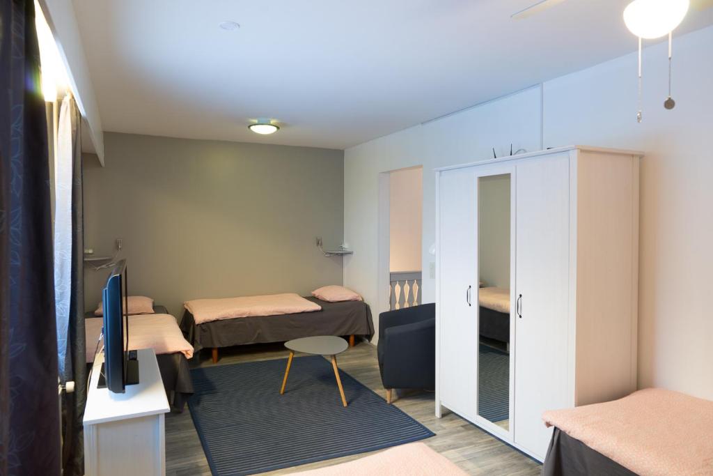 um quarto com duas camas e uma tv nele em Guesthouse Borealis Apartments em Rovaniemi