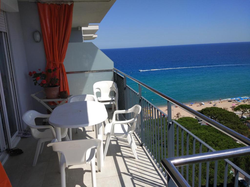 a balcony with a table and chairs and the beach at Atico Condal in Blanes