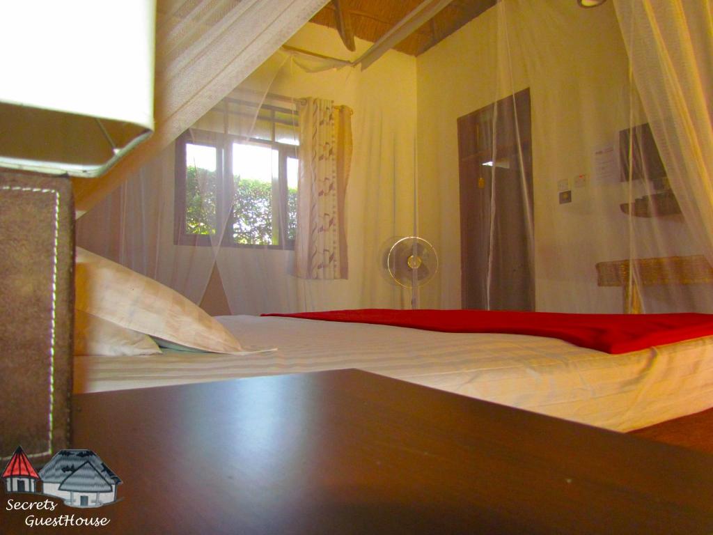 Secrets Guest House tesisinde bir odada yatak veya yataklar