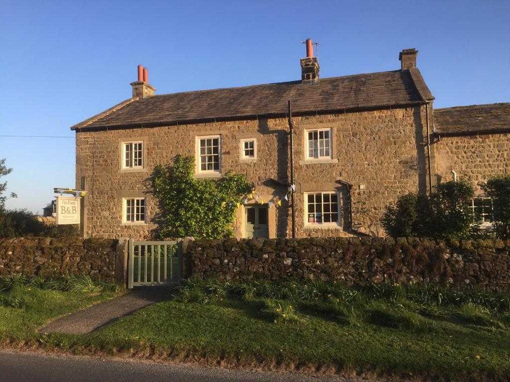 ein altes Steinhaus am Straßenrand in der Unterkunft Firs Farm B&B in Masham