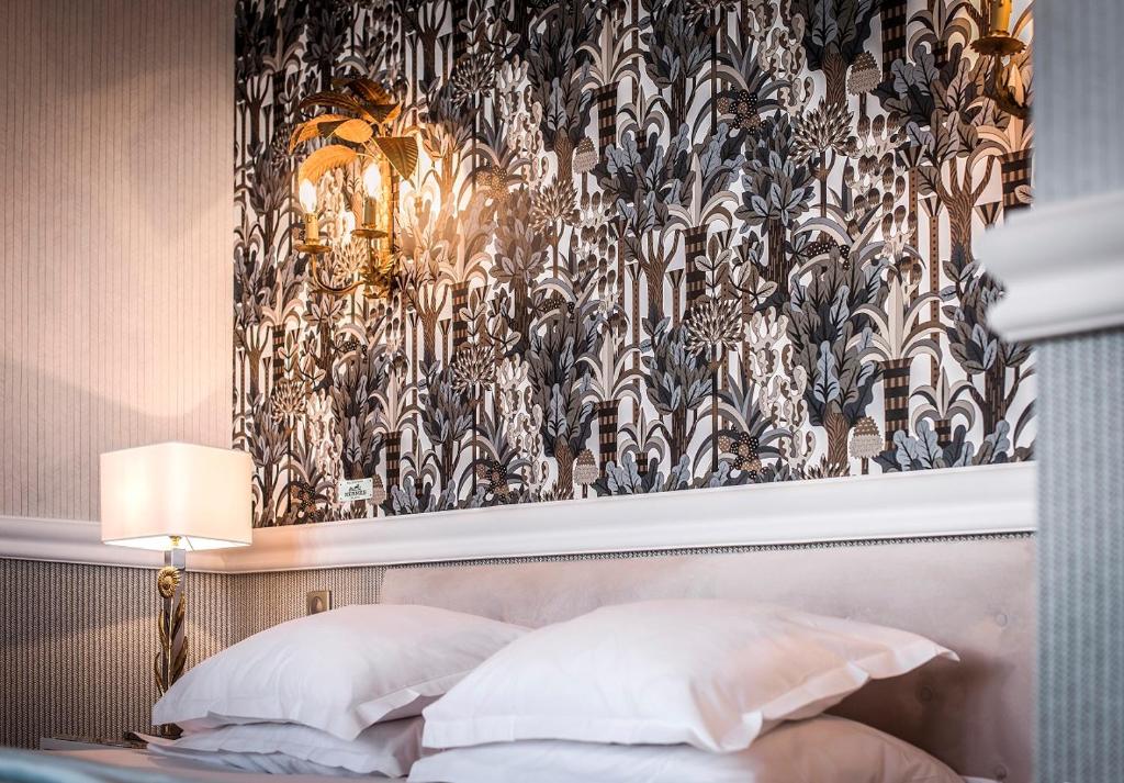 a bedroom with a bed with a black and white wallpaper at Hôtel Belles Rives in Juan-les-Pins