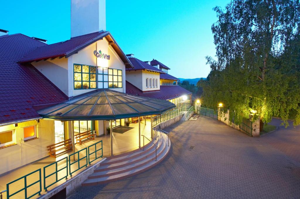 a building with a fence next to a street at Geovita Lądek Zdrój in Lądek-Zdrój