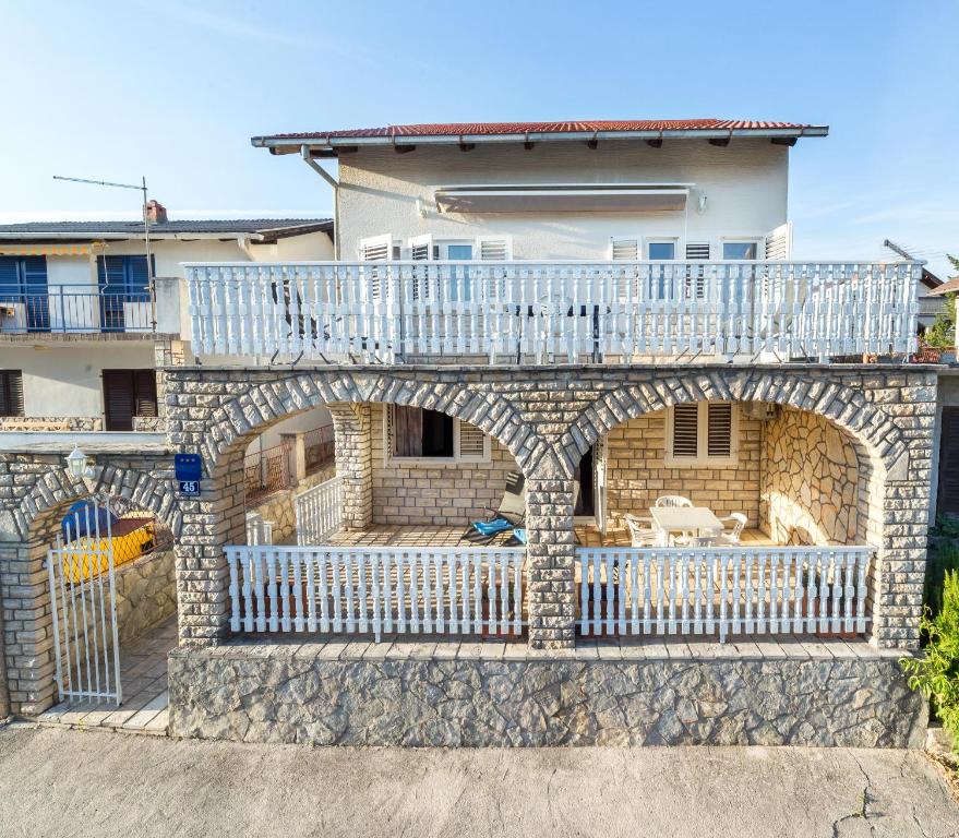une maison avec un balcon au-dessus d'un bâtiment dans l'établissement Apartments The heart of Croatia, à Pirovac