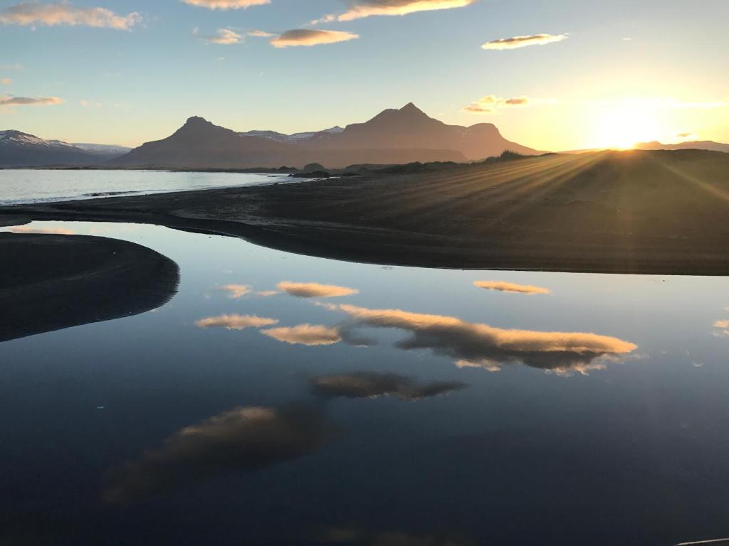 un reflejo del cielo en un cuerpo de agua en Framtid Apartments and Holiday Homes, en Djúpivogur