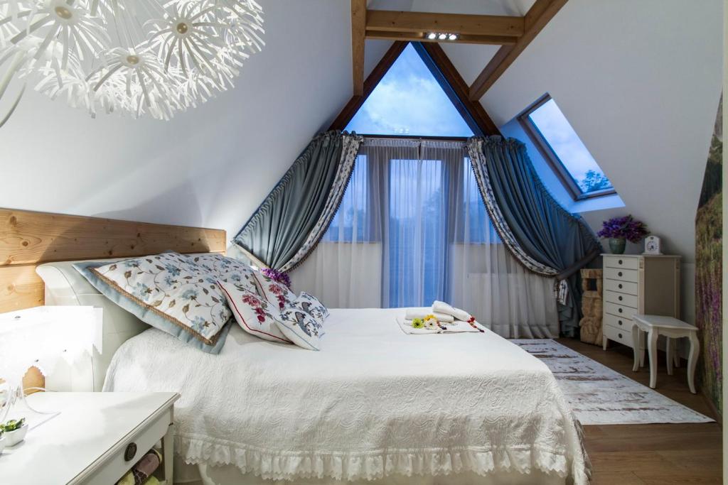 een slaapkamer met een bed en een groot raam bij Rezydencja Tatry - Apartament Chamerion 1 in Zakopane