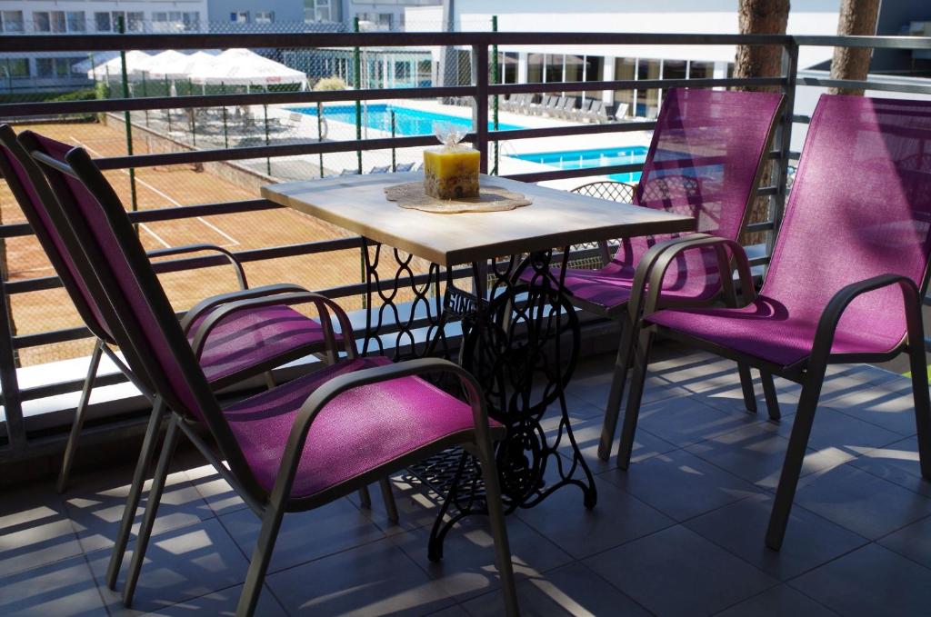 a table and chairs on a balcony with a pool at Apartament Żarko in Pogorzelica
