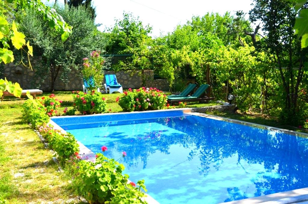a swimming pool in a yard with flowers at Villa Lapaz Esintisi in Kalkan