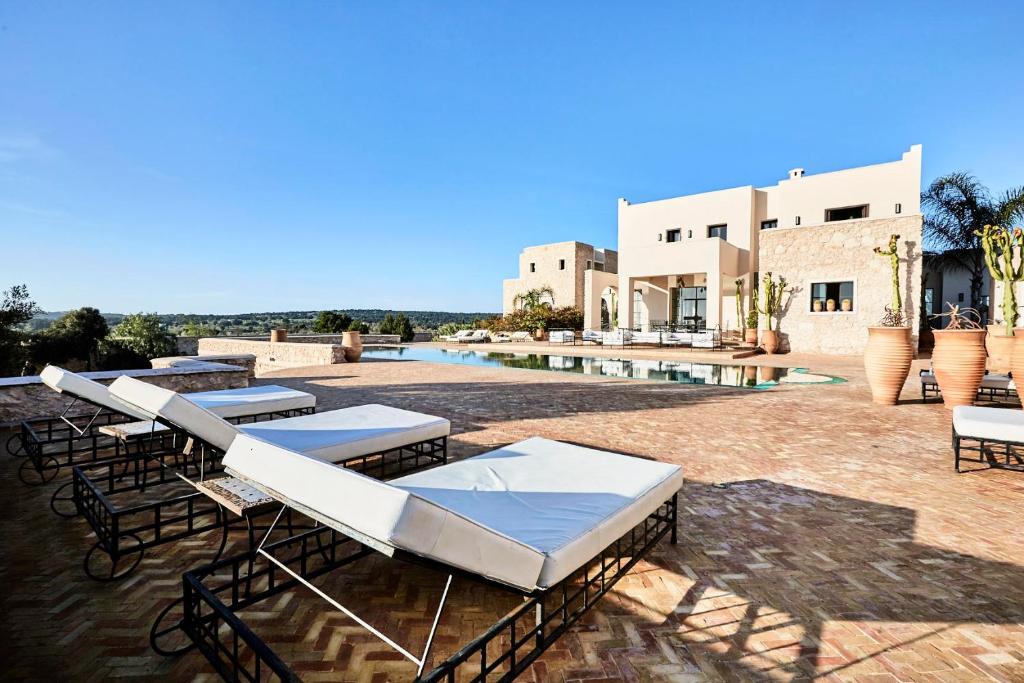 - un ensemble de tables et de chaises sur une terrasse dans l'établissement Maison D'hôtes, SPA et YOGA Villa Océane, à Essaouira