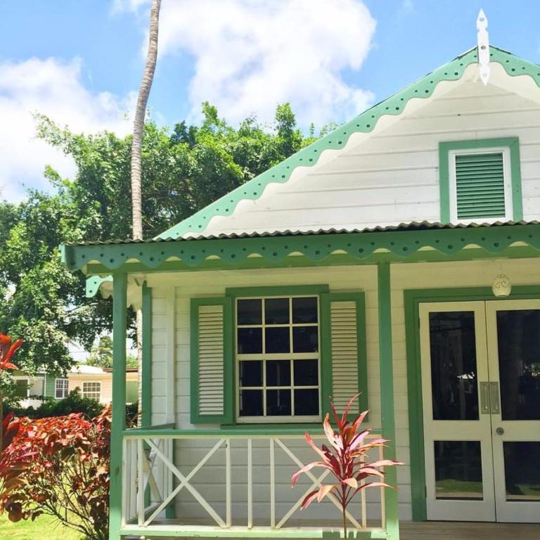 a small green and white house with a white roof at Cobblers Cove - Barbados in Saint Peter