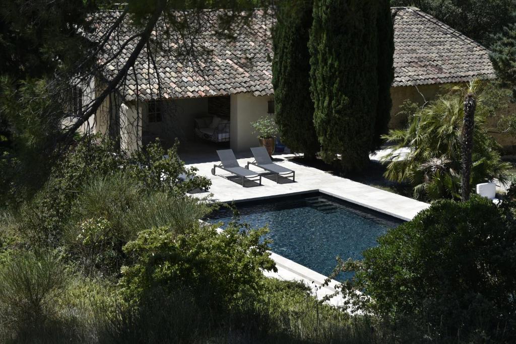 a swimming pool with two lounge chairs next to a house at Campagne Paumier in Ansouis