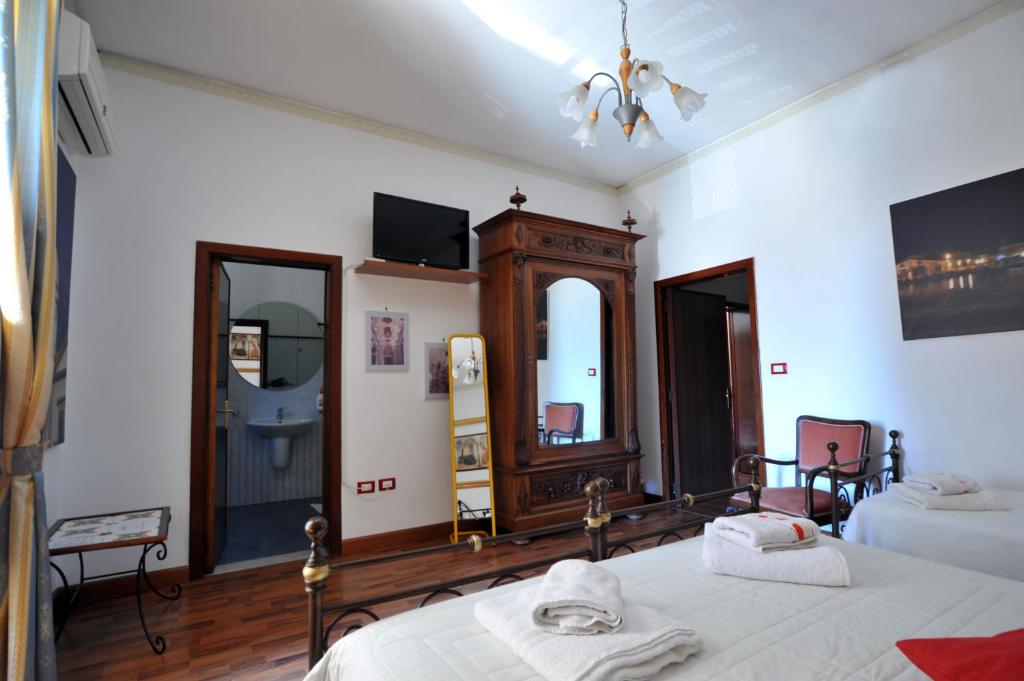 a bedroom with two beds and a mirror at Il Giardino Di Pietra in Noto