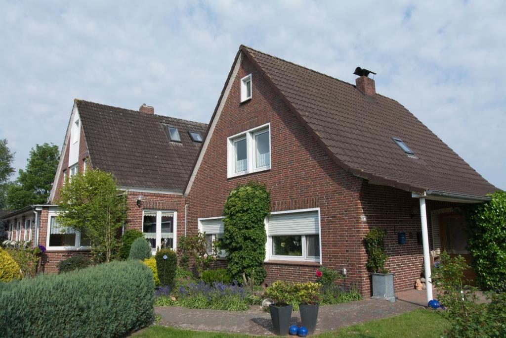 ein rotes Backsteinhaus mit braunem Dach in der Unterkunft Pension Murra in Stedesdorf