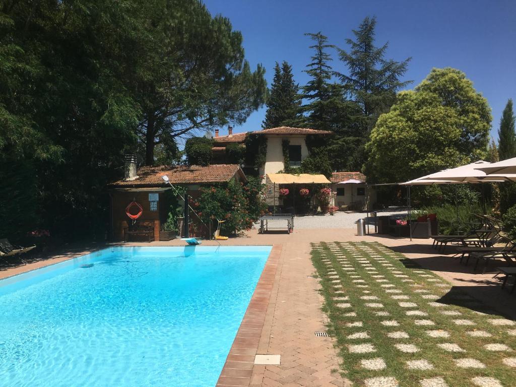 a large swimming pool in a backyard with trees at Agriturismo Il Paradiso in Asciano