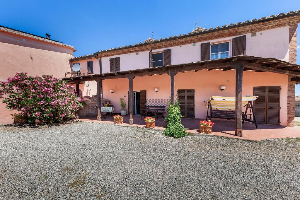 a house with a patio with a table in it at Agriturismo Quercetelli in Castiglione del Lago