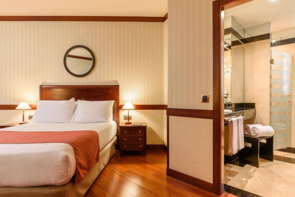 A bed or beds in a room at Eurostars Gran Hotel Santiago