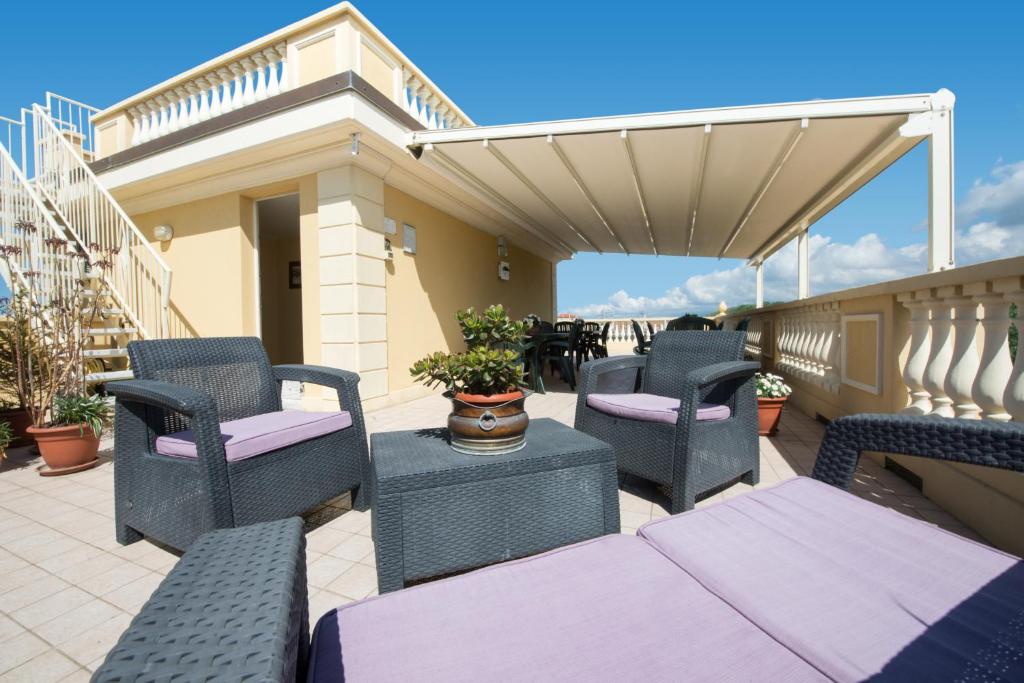 a patio with chairs and tables on a balcony at Residence Colombo in Viareggio