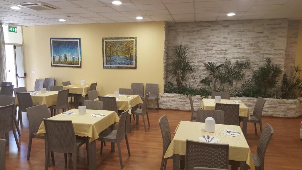 a restaurant with tables and chairs in a room at Hotel Corallo in Francavilla al Mare