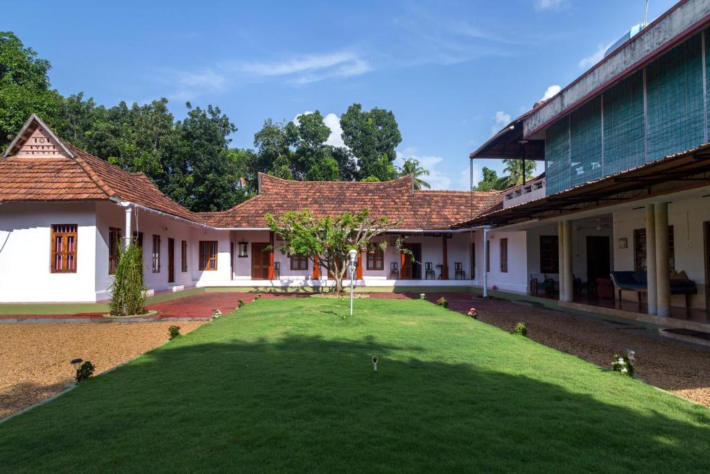 una casa con un grande prato di fronte di Akkara Homestay & Ayurveda a Kottayam