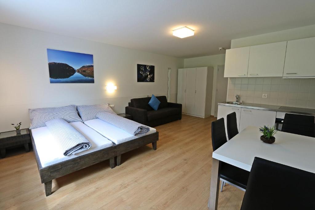 uma sala de estar com uma cama e uma cozinha em b&b River Inn em St. Moritz
