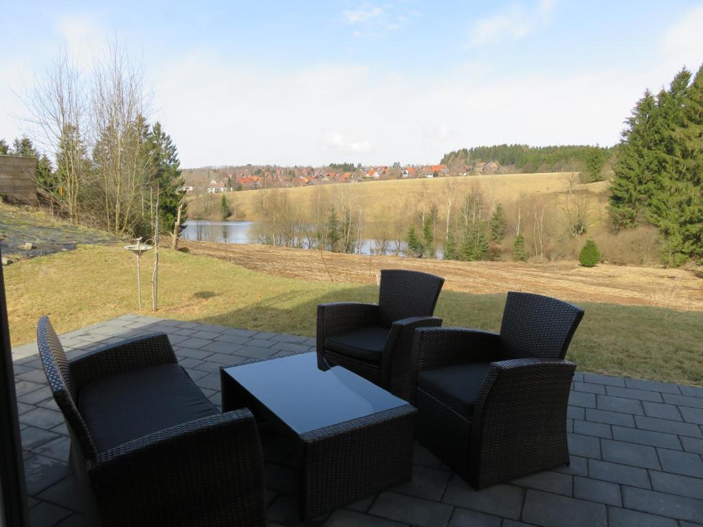 een patio met stoelen, een tafel en een veld bij Appartement Max in Clausthal-Zellerfeld