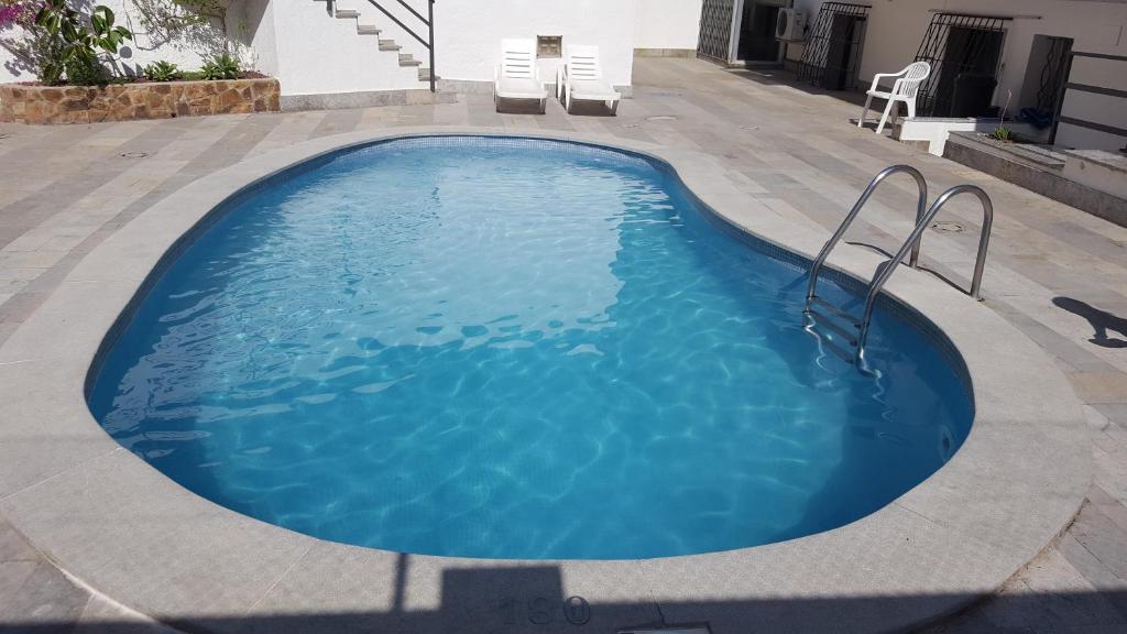 a swimming pool with blue water in a yard at Apartamento Blanes in Blanes