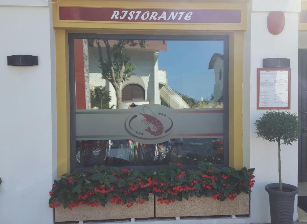 a window of a restaurant with flowers in a window box at Hotel Corallo in Francavilla al Mare