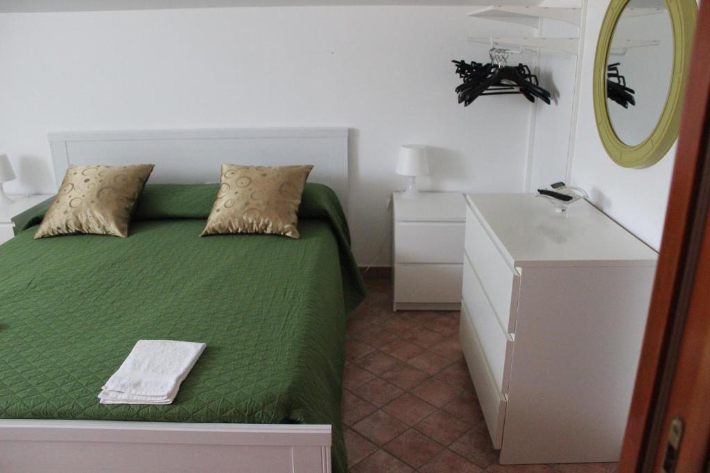 a bedroom with a green bed and a mirror at B&B Pizzo Cannicchio in Matera
