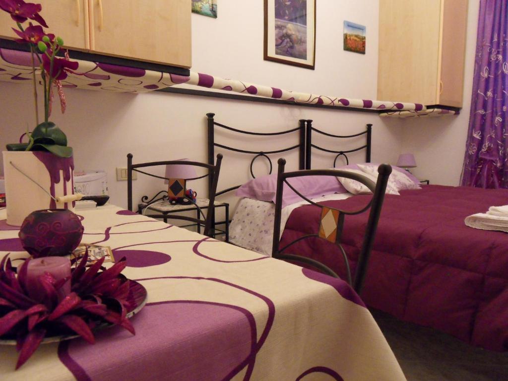 アンツィオにあるDi mare e di Saleの紫と白のシーツが備わる客室のベッド2台