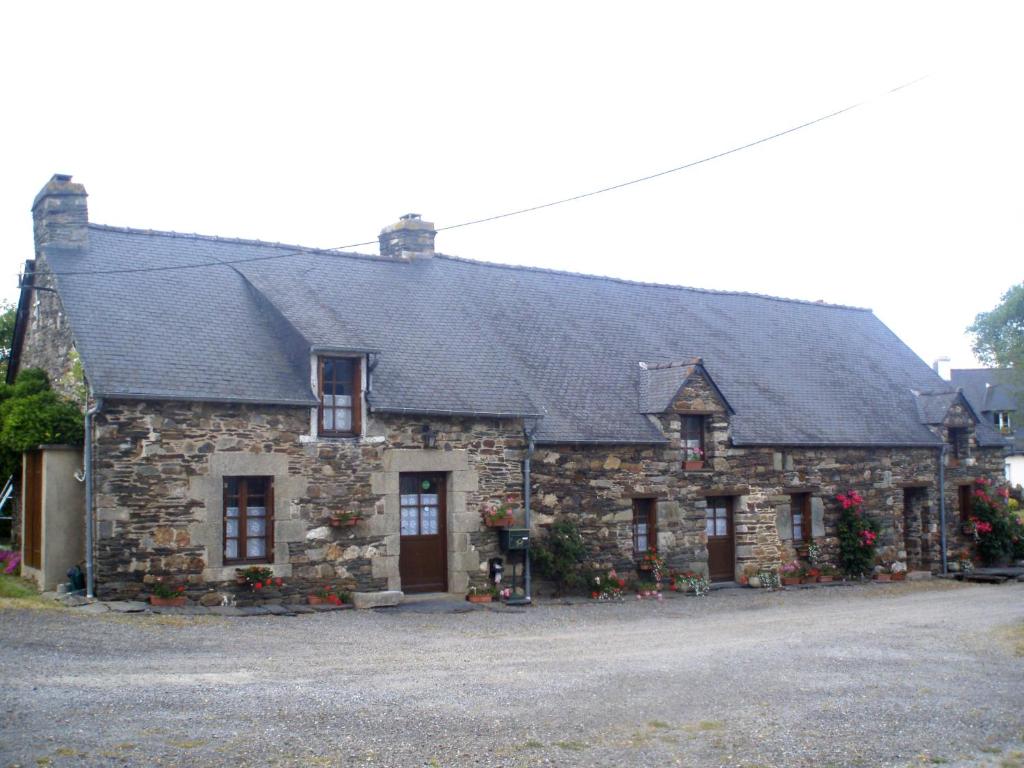 a stone house with a black roof at Chambres Kercymado in Mûr-de-Bretagne